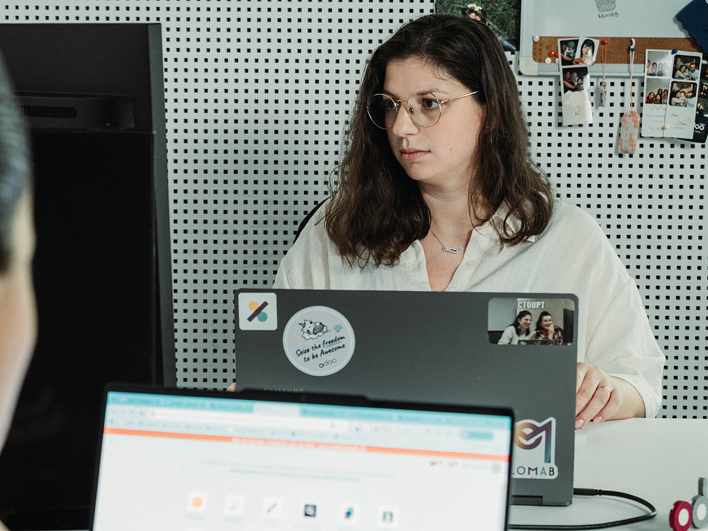 Eva Lombardo à son poste dans les bureaux d'Elomab, derrière un ordinateur portable qui affiche l'écran d'accueil des applications Odoo