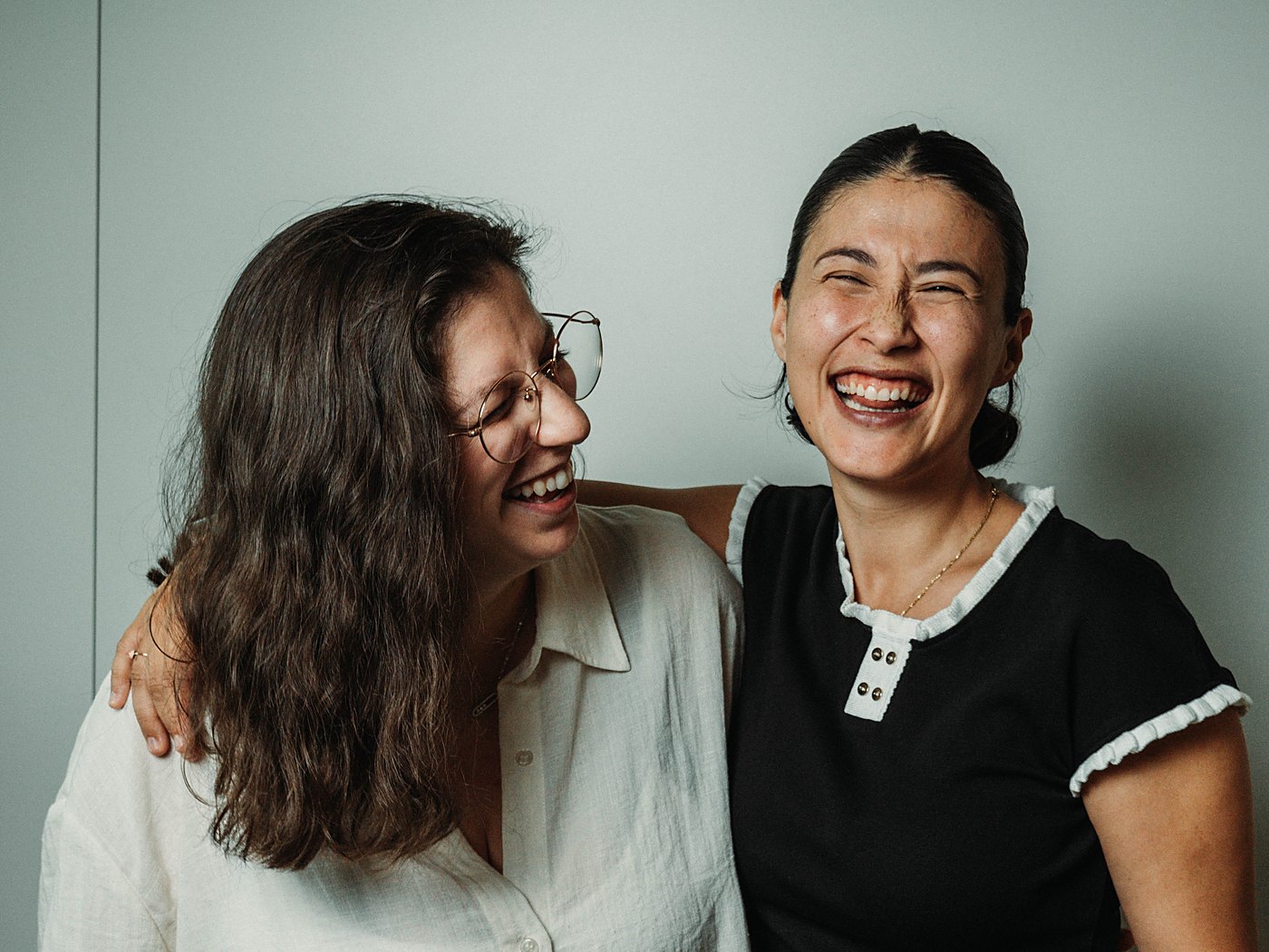 Les deux fondatrices d'Elomab qui éclatent de rire, l'une le bras sur l'épaule de l'autre, devant un mur gris clair